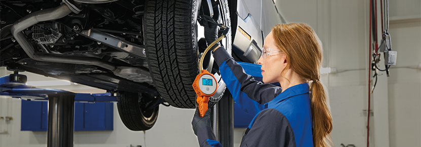 A Subaru technician checking tire pressure. | Subaru of Utica in Yorkville NY
