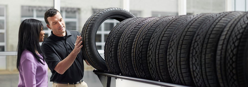 Subaru service representative showing customer a tire. | Subaru of Utica in Yorkville NY
