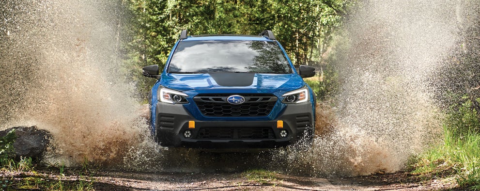 A 2023 Outback Wilderness driving on a muddy trail. | Subaru of Utica in Yorkville NY